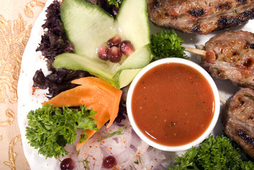 Fried meat served with tomato sauce and salad