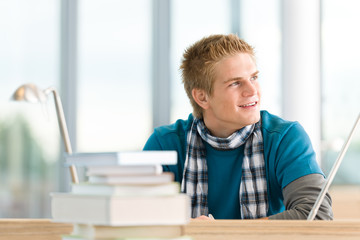 Obraz premium Male student with books sitting at table