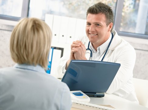 Smiling doctor talking to patient