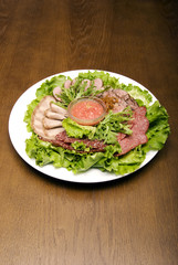Appetizer made of  meat delicacies and salad