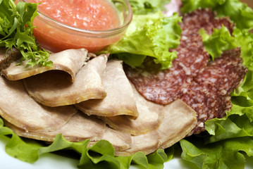 Appetizer made of  meat delicacies and salad