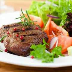 Photo sur Plexiglas Steakhouse Grilled steak with fresh vegetables and herbs