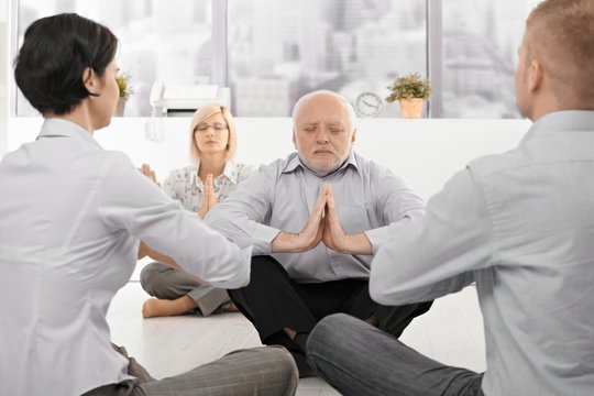 Businesspeople exercising yoga in office