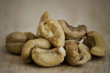 Heap of a roasted cashew nuts on an old wooden table.