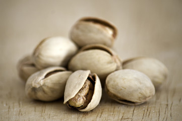 Salty nuts of roasted pistachio on an old wooden table.