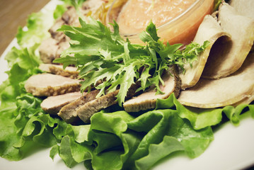 Appetizer made of  meat delicacies and salad