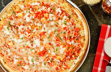 Whole Frozen pizza with cutter and napkin