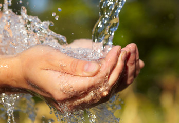 Fototapeta premium Woman's hands with water splash