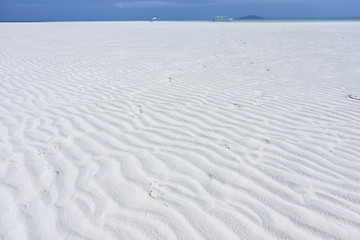 Fototapeta na wymiar White sand beach with boat in the background