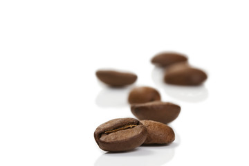 kaffeebohne vor anderen auf weissem hintergrund