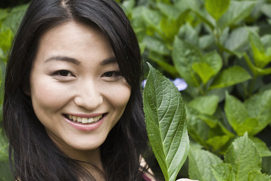 Smiling Japanese woman holding leaf