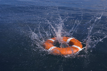 Round life preserver splashing into water