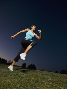 Mixed race woman running on grass