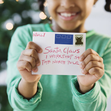 African American girl holding letter to Santa Claus