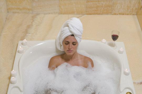 Hispanic woman relaxing in bubble bath