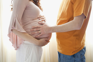 Hispanic man touching pregnant wifeÕs stomach