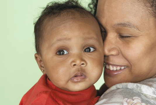 Mixed race mother holding baby daughter