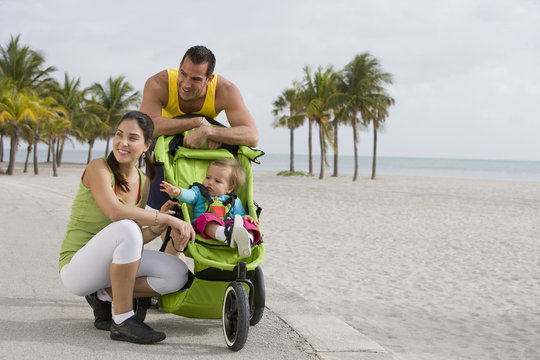 Hispanic couple stopping with baby in jogging stroller - Powered by Adobe