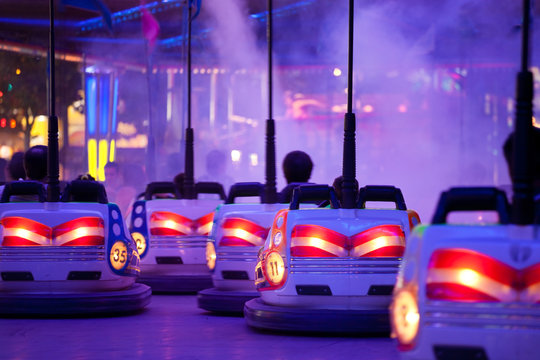 Bumper cars, driving through artificial smoke. Motion blur