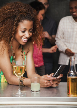 Woman text messaging at bar