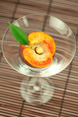peach in the martini glass on a bamboo mat