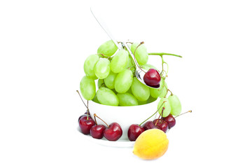 cup of grapes, cherries and apricots isolated on white