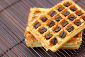 waffles and coffee beans on a bamboo mat