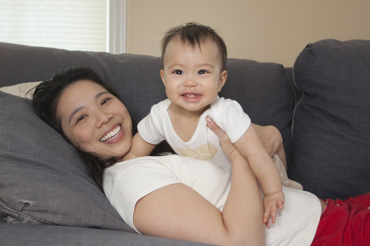 Chinese mother and baby on sofa