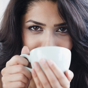 Close up of Middle Eastern woman drinking coffee
