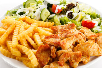 Grilled meat, French fries and vegetables