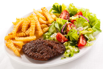 Grilled meat, French fries and vegetables