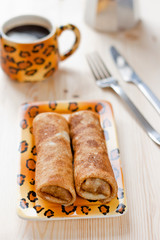 Pancakes with meat filling on the wooden table