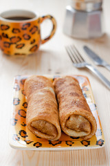 Pancakes with meat filling on the wooden table