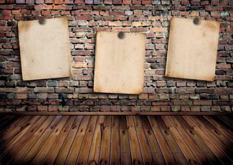 Three paper poster on a brick wall