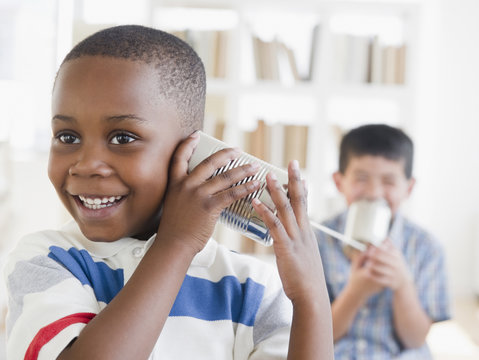 Boys playing with tin can telephone