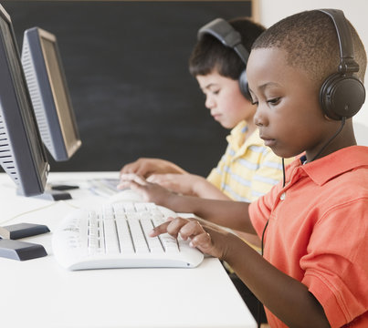 Boys typing on computers in computer lab