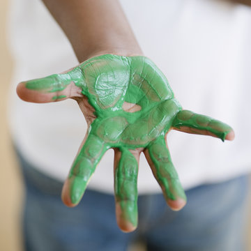 Black Boy With Green Paint On Hand