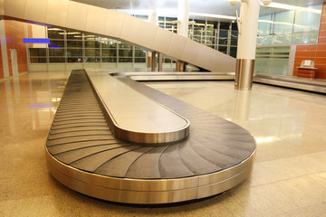 empty baggage carousel in airport hall with granite floor