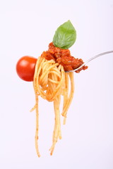Spaghetti bolognese hanging on a fork with a cherry tomato