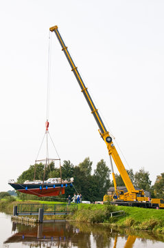 Autokran hebt Motorboot