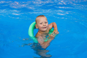 Fototapeta na wymiar Little boy swimming in the pool