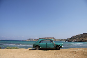 Old rusty car parked by the beach