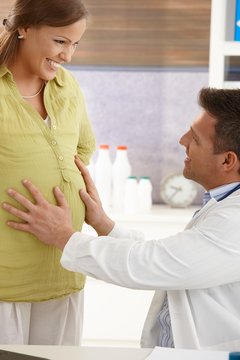 Doctor touching pregnant belly