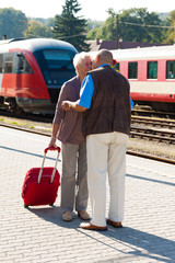 Älteres Senioren Paar am Bahnhof. Reisen in den Urlaub