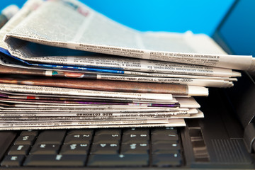 Stack of newspapers on laptop