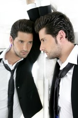 Handsome narcissistic young man looking in a mirror