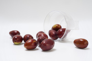 Jujubes with transparent cup of coffee fallen