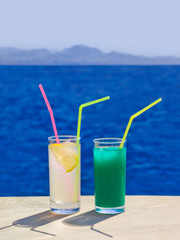 Two cocktails on marble table at beach