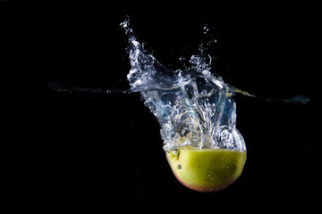 Apple splashing on black background