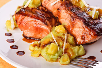 Salmon with mashed avocado and mango (close-up)